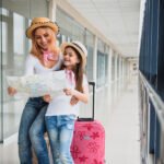 happy mother and daughter at airport travelling together